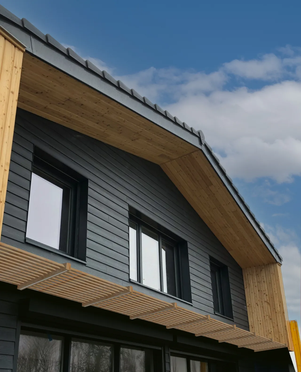 Vue centrée sur l'auvent de la maison individuelle à ossature bois construite par Alternative Bois Concept à Rexpoëde.